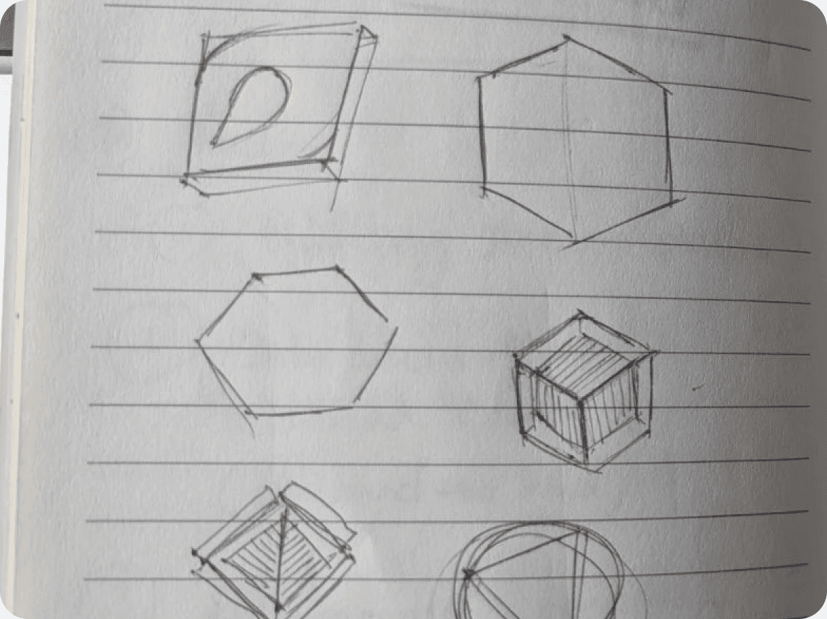 Notebook page of coin shape sketches: hexagons, cubes and a teardrop D